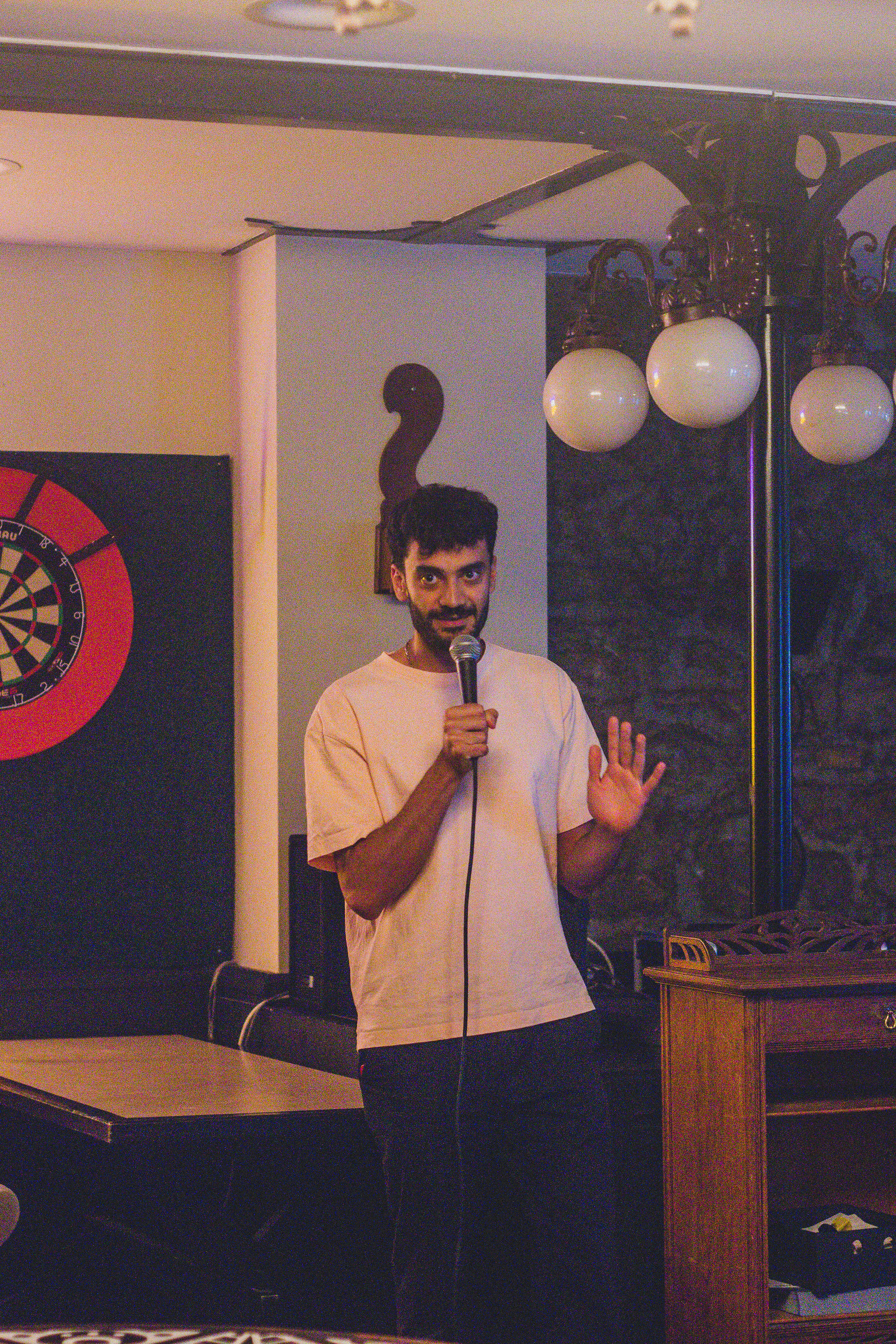 Pouya performing stand-up at IN YOUR FACE Comedy in Zürich