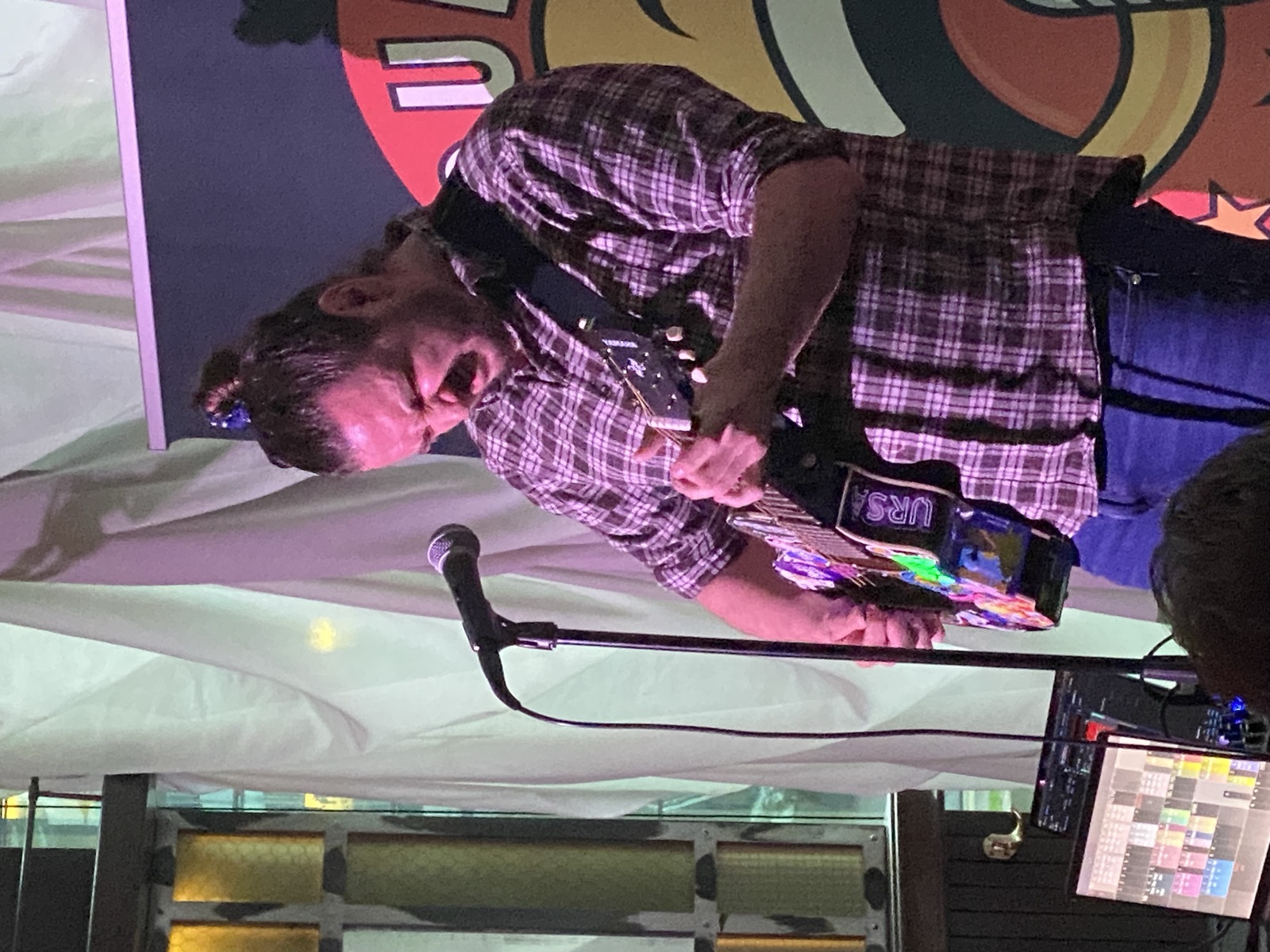 IN YOUR FACE Comedy, a comedian performing stand-up with a microphone on stage in Zürich (2024)