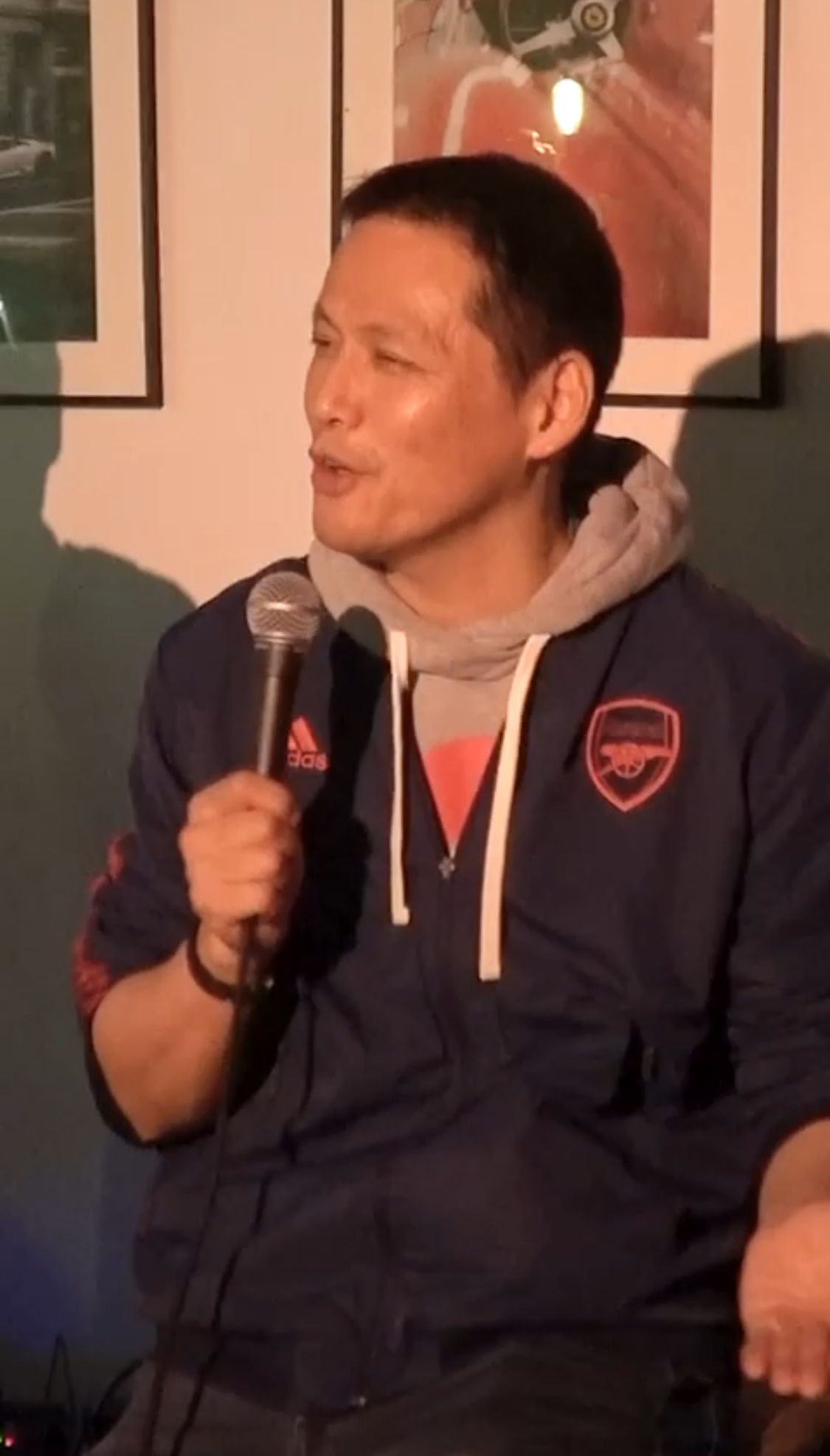 IN YOUR FACE Comedy, a comedian performing stand-up with a microphone on stage in Zürich (2025)
