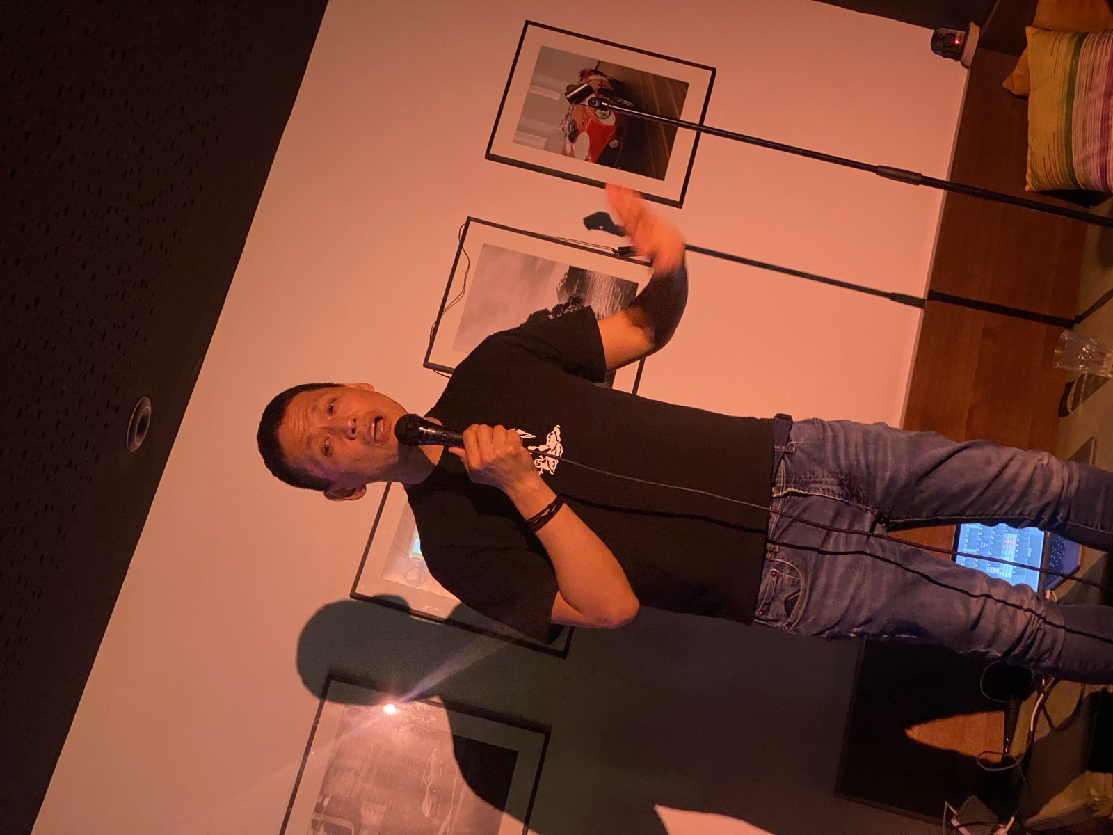 IN YOUR FACE Comedy, a comedian performing stand-up with a microphone on stage in Zürich (2025)