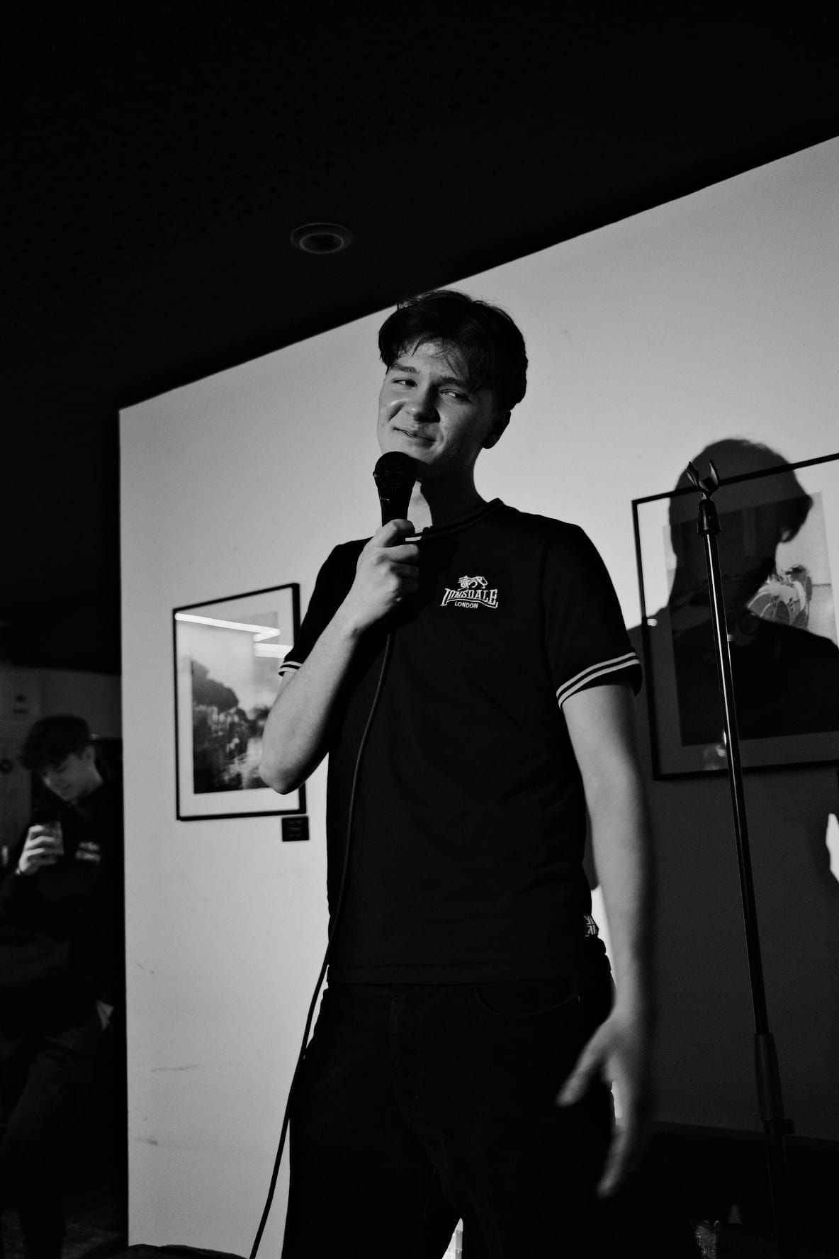 IN YOUR FACE Comedy, Ben Fücks performing stand-up with a microphone on stage in Zürich (2024)